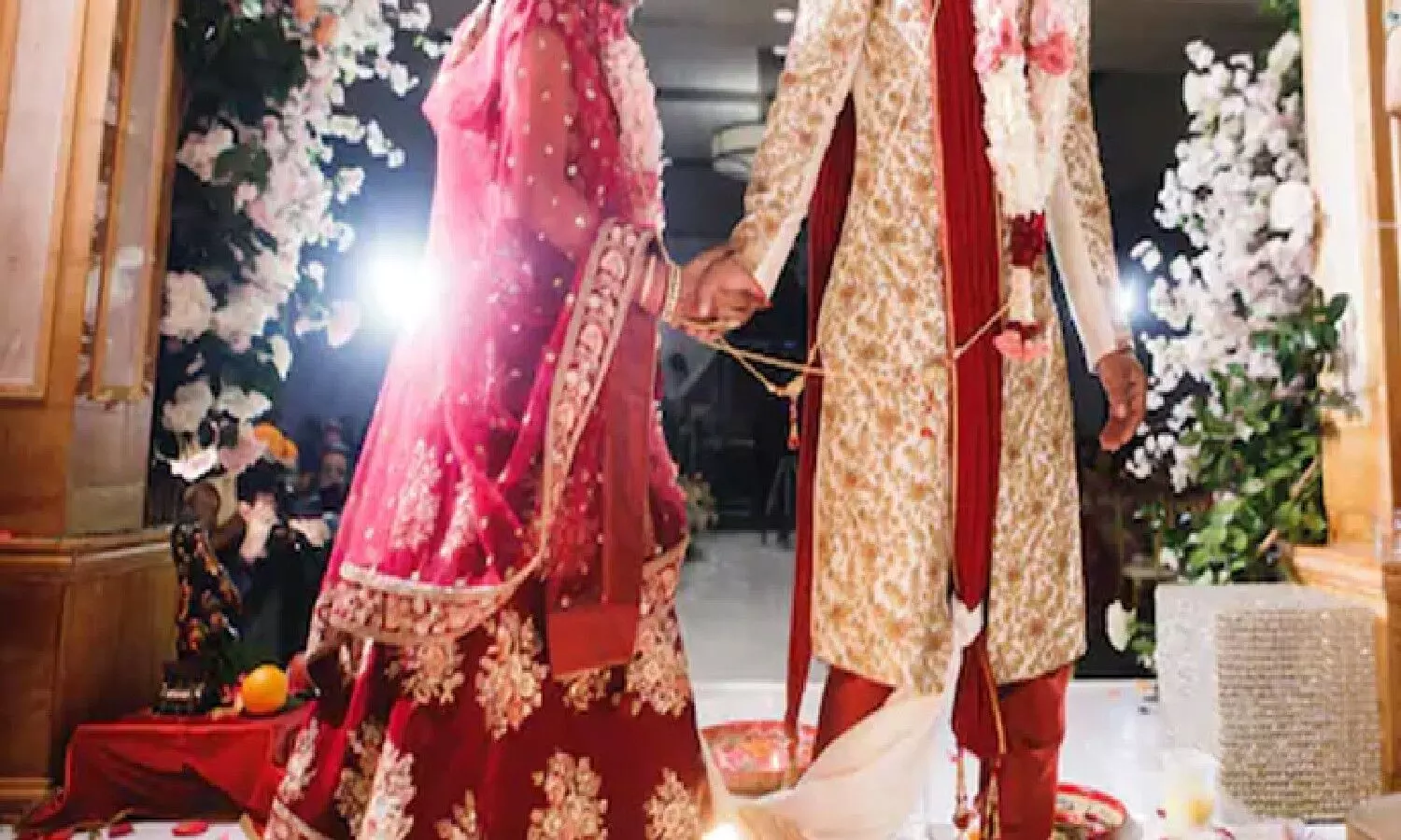 At the wedding ceremony, two grooms arrive at the pavilion to marry a bride.