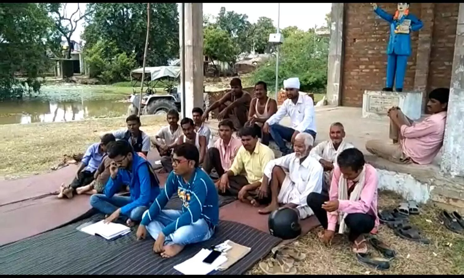 Villagers protesting infront of Ambedkar statue