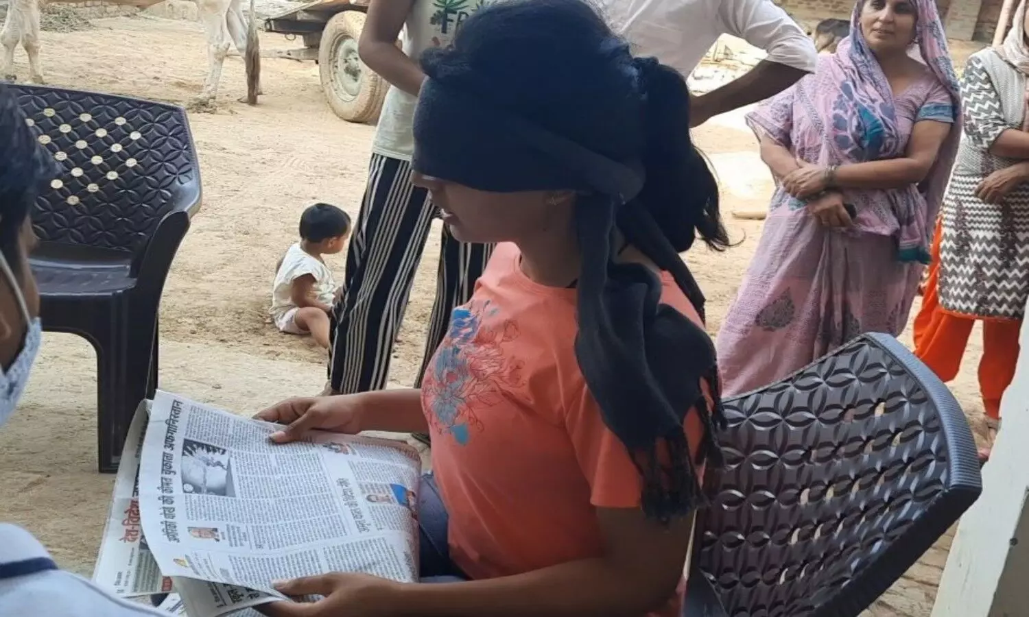 Diksha reading newspaper with closed eyes
