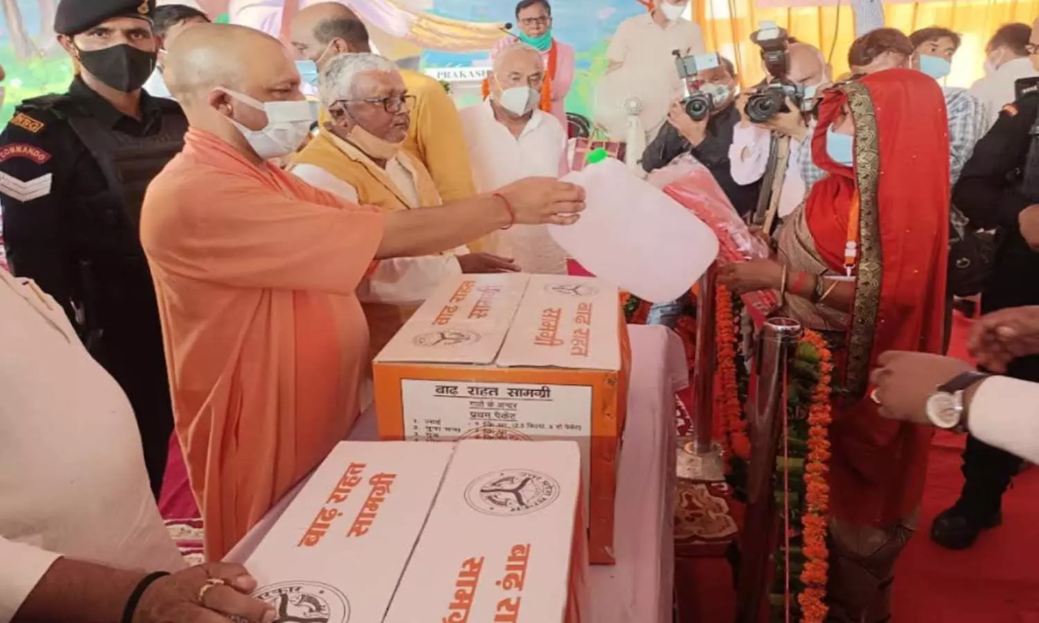CM Yogi Adityanath giving relief material to the flood victims