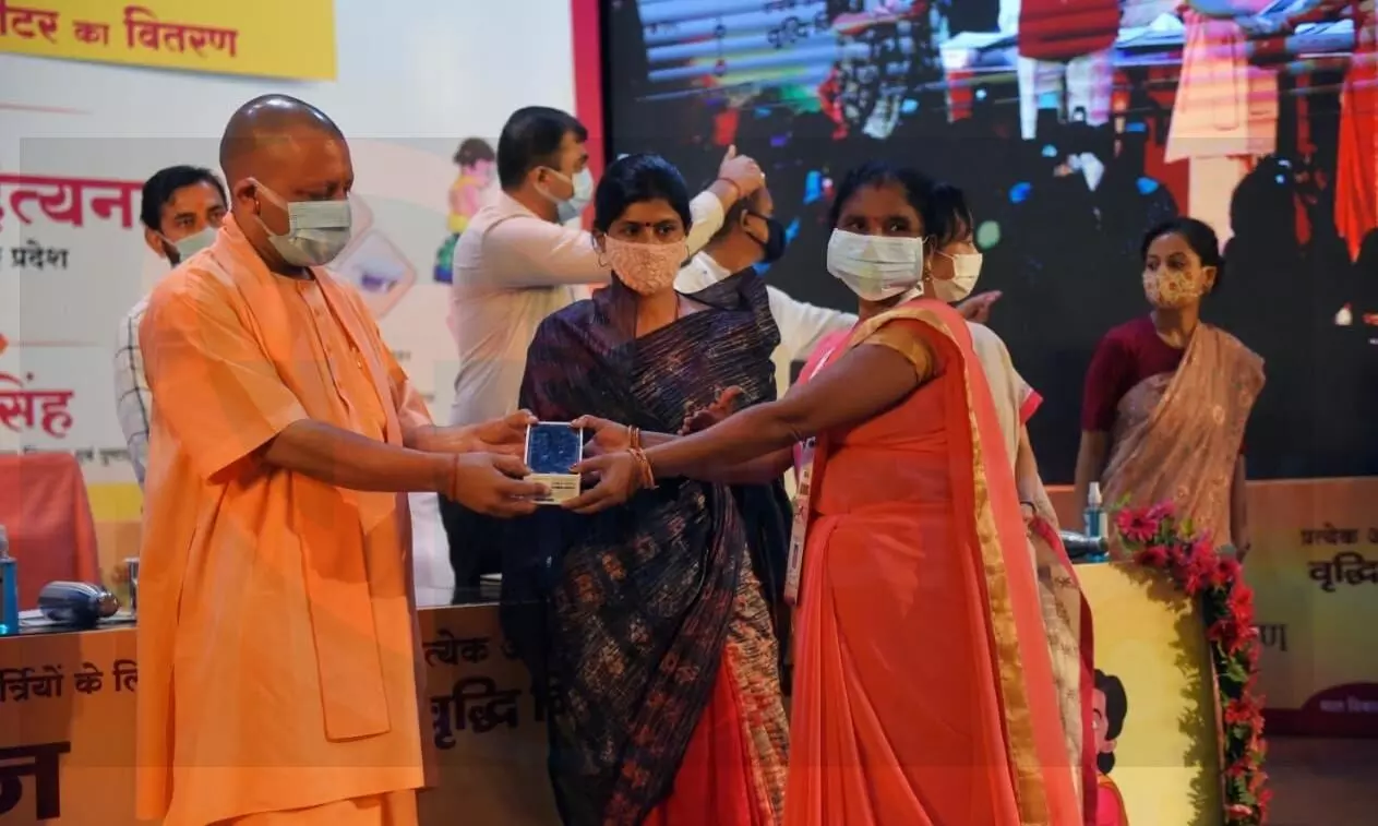 Yogi giving phone to Anganwadi woman