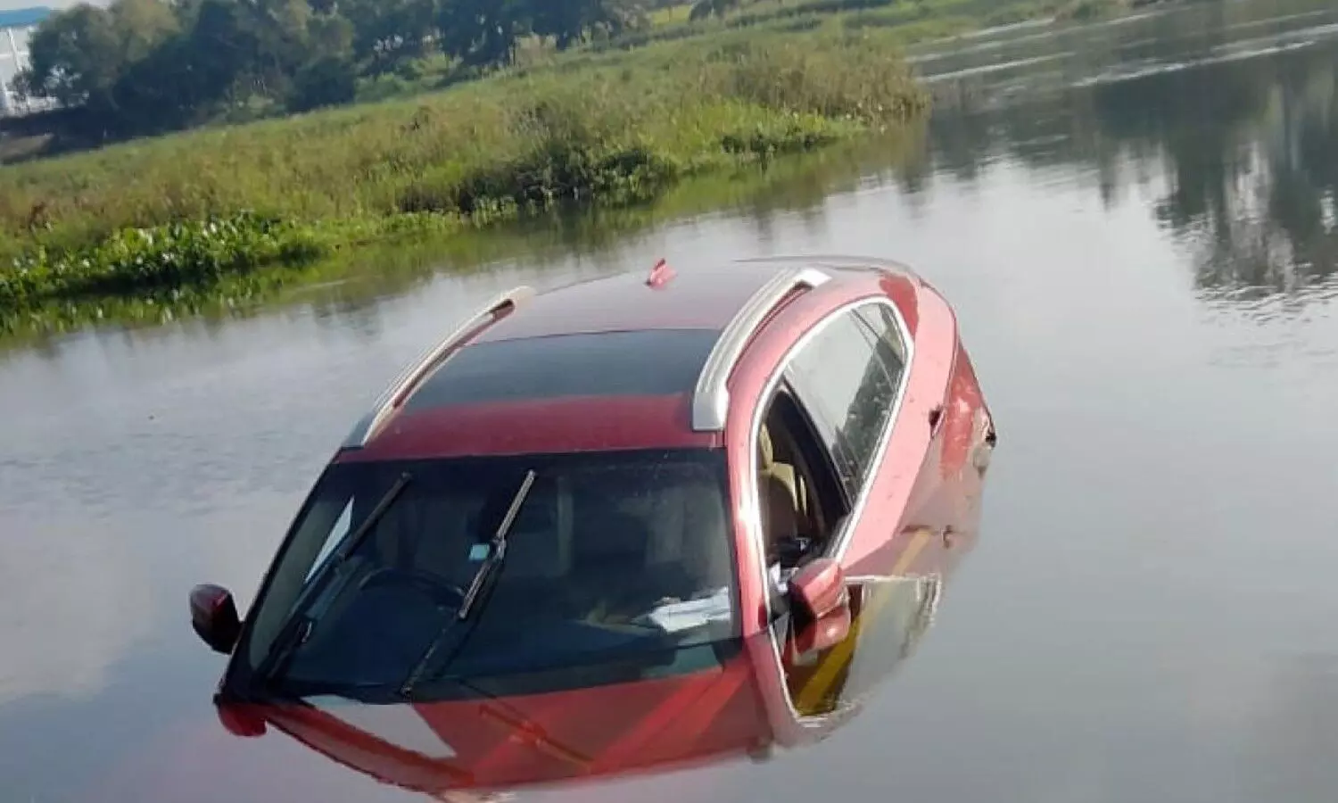 Expensive red colored BMW car in river Kaveri
