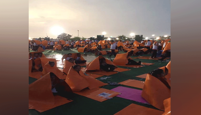 PHOTOS: PM मोदी के योग कार्यक्रम के पहले लखनऊ में हुई बारिश, लोगों ने योगा मैट को बनाया छाता