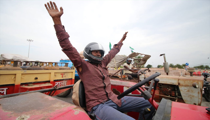 नए मोटर एक्ट के विरोध में किसानों का प्रदर्शन, ट्रैक्टर चलाते समय लगाया हेलमेट